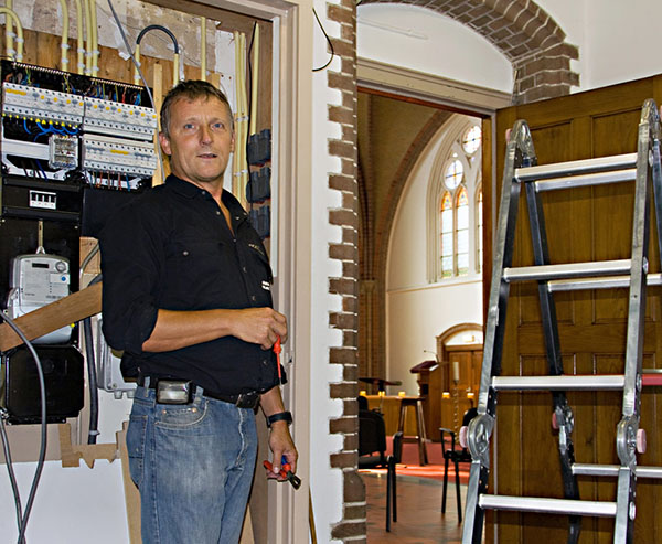 Peter Senhorst uit Giesbeek bezig met het vervangen van de meterkast in de St. Martinuskerk in Giesbeek (foto: Ina Kotterman). Gepubliceerd zaterdag 7 september.