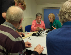 April 2012: Wies van Well (in roze trui) maakt haar eigen pinhole lens tijdens een workshop in het kader van het 50-jarig bestaan van de fotokring.